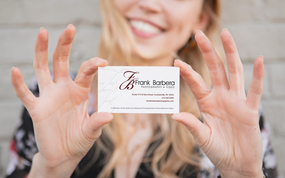 Smiling woman holding Frank Barbera Photography Business Card.